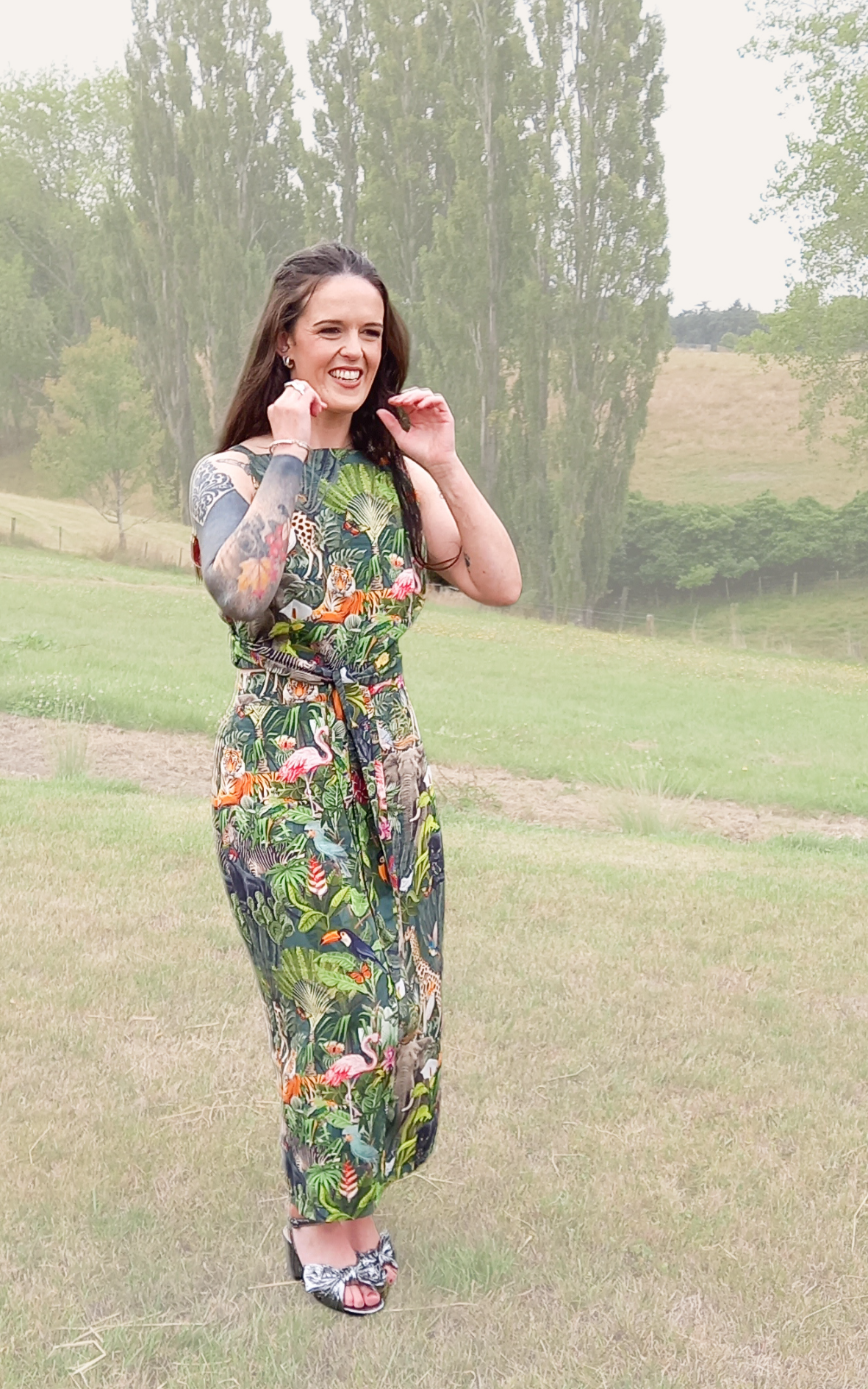 Tattooed woman wearing safari print rental dress set with waist tie and pencil skirt in countryside
