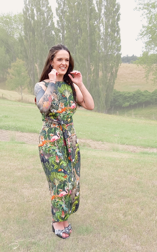 Tattooed woman wearing safari print rental dress set with waist tie and pencil skirt in countryside