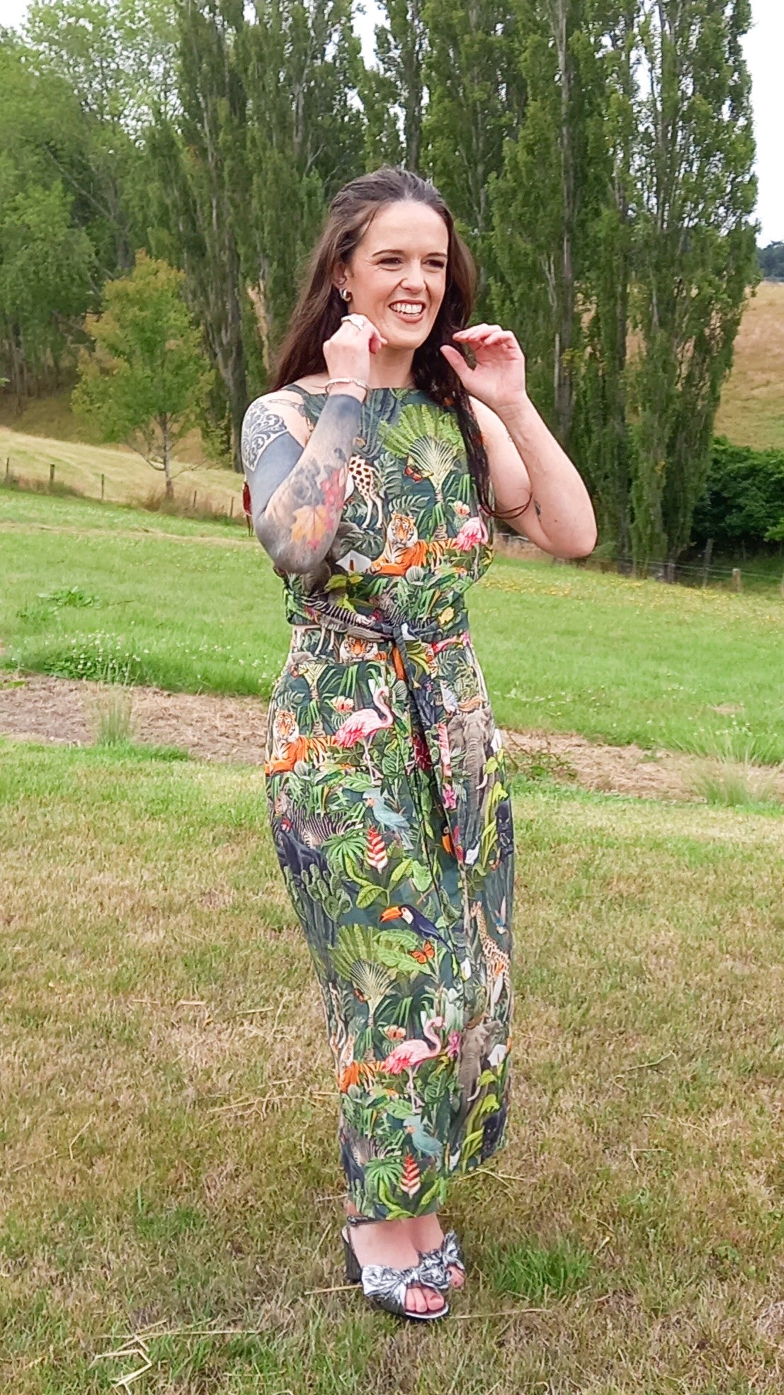 Tattooed woman wearing safari print rental dress set with waist tie and pencil skirt in countryside